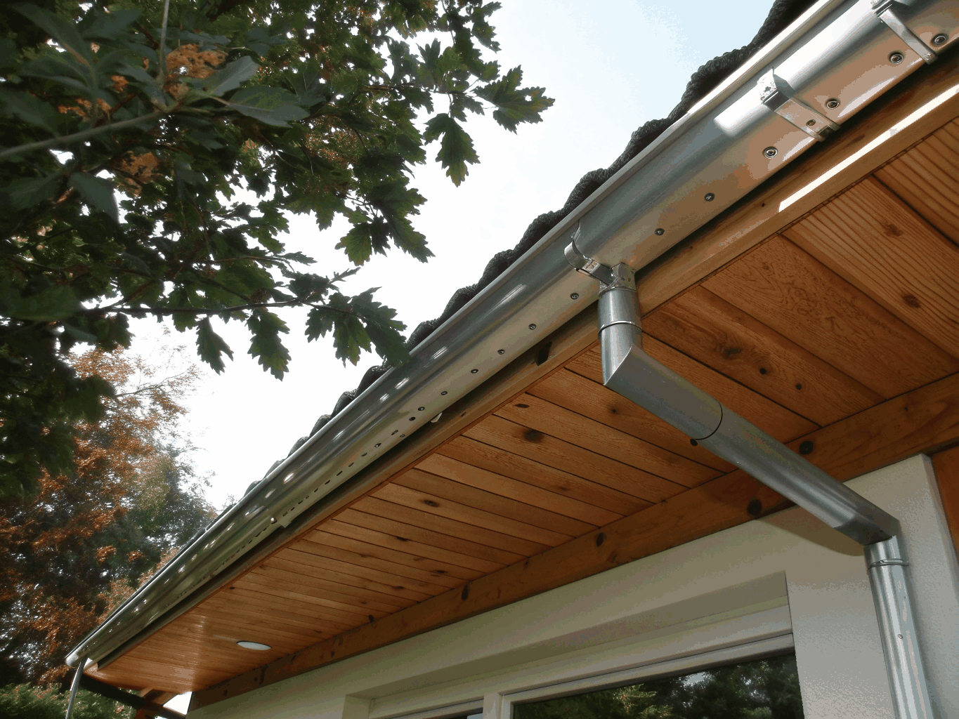 Exterior view of an architectural gable extension with exposed rafter tails and matching shingle work
